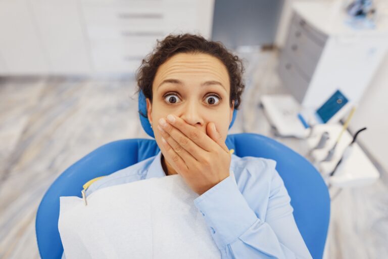 imagen de una paciente en el gabinete del dentista con miedo