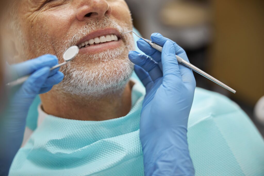 imagen de un paciente sentado en el sillon del dentista mientras el dentista le evalua